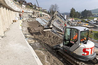Weisser Bagger auf der Baustelle am Baggern