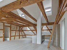Foto von Dachgeschoss mit hellen Holzbalken und hellem Holzboden