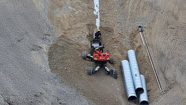 Foto von Bauarbeiten in einer Grube mit Menzi Mucki Bagger
