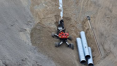 Foto von Bauarbeiten in einer Grube mit Menzi Mucki Bagger