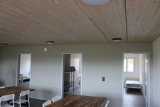 Heller Wohn- und Essbereich mit Holzdecke und Blick in Zimmer.