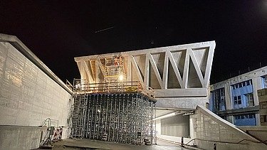 Sonderschalung mit Baustellengerüst und fertigem Betonguss bei Nacht