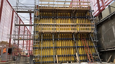 Foto von Arbeiten an einer gelben Holzschalung für Betonwände