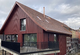 Foto von umgebautes Bauernhaus mit Holzverkleidung in dunkelrot