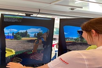 Eine Frau mit Zopf und STRABAG T-Shirt steuert einen Bagger-Simulator mit einem Joystick.