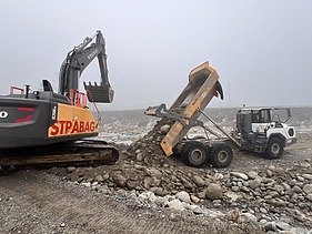 Foto von Arbeiten auf Sandbank der Reuss mit gelben STRABAG Bagger