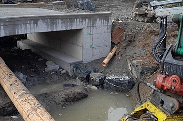 Bauarbeiten in Horgen am Durchlassbauwerk - STRABAG Tiefbau Foto von Durchlassbauwerk mit Rohren und Wasser auf Schlammboden