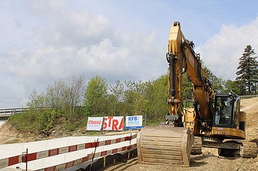 Bauarbeiten in Egerkingen - STRABAG Verkehrswegebau Foto von gelben Bagger bei einer Baustelle von STRABAG