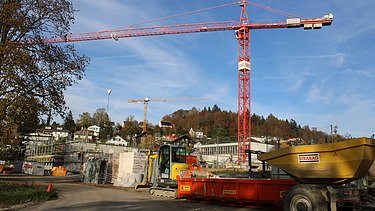 Foto von Rohbau im Vordergund ein Dumper und roter Kran