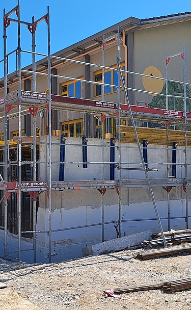 Die Baustelle «Erweiterung Schulareal» eingekleidet mit einem Gerüst ringsherum.