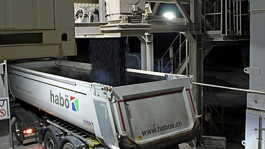 Fertige Asphaltmischung wird in den Lastwagen gekippt.