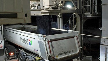 Fertige Asphaltmischung wird in den Lastwagen gekippt.