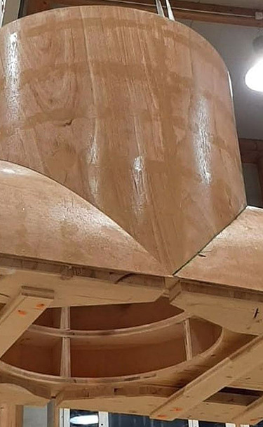 Nachtaufnahme einer STRABAG-Baustelle. Ein grosser Kran steht beleuchtet neben einem Wohnhaus unter dem klaren Nachthimmel.