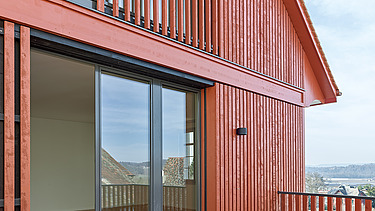 Foto von Balkon aus hellem Holz und Hausverkleidung in rot-braunem Holz