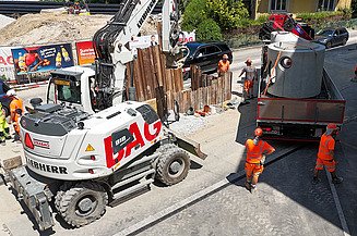 Bohrer vor einer Reihe von Stahlträgern der Rüphlwand.