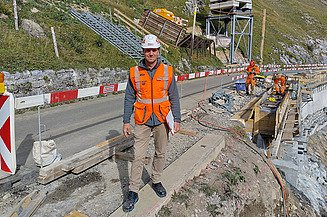 Perspektive mit der Baustelle und zwei Mitarbeitenden im Hintergrund