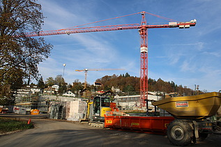 Foto von Rohbau im Vordergund ein Dumper und roter Kran