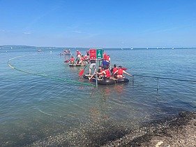 Lernende fahren mit selbstgebauten Flossen auf dem Bodensee.