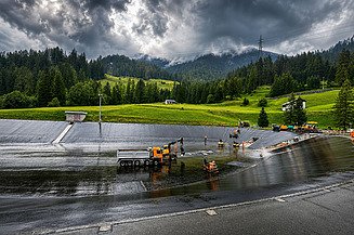Perspektive aus Distanz mit Blick auf halbes Becken mit Maschinen und Bauerarbeitern auf dem Bild