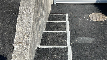 Zwei grosse Hebevorrichtungen auf einer STRABAG-Baustelle. Im Hintergrund sind Bauarbeiter:innen und ein Kran zu sehen.