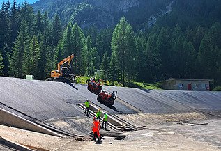 Perspektive aus grösserer Distanz, mit Baumaschinen und Mitarbeitenden im Bildmittelpunkt