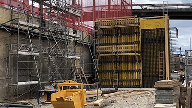 Foto von Arbeiten an einer gelben Holzschalung für Betonwände