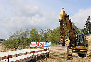 Foto von gelben Bagger bei einer Baustelle von STRABAG