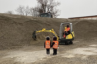 Foto von zwei Kindergartenkinder beim Mini-Bagger