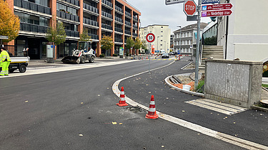  Ein Kran der STRABAG hebt nachts ein langes Brückenteil über Bahngleise. Die Baustelle ist hell erleuchtet.
