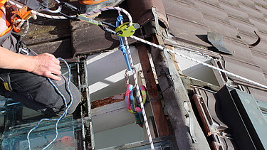 Sicherungsseil am Dachstuhl mit Flaschenzug und Sicherungsmanschetten. 