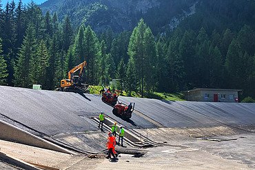 Perspektive aus grösserer Distanz, mit Baumaschinen und Mitarbeitenden im Bildmittelpunkt