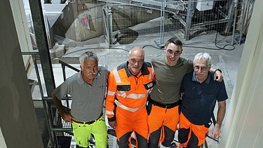 Vier Männer von oben, hinten das Belagswerk