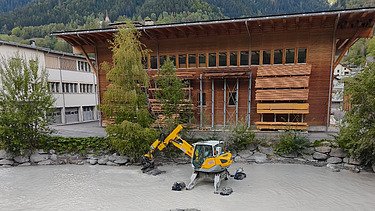 Voller Geschiebesammler mit schwerem Gerät im Wasser
