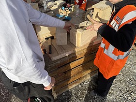 Schüler bekommt Hilfe von einem Zimmermann Lernenden beim bau des Vogelhäuschens