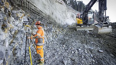 Bauarbeiter mit Vermessungsequipment