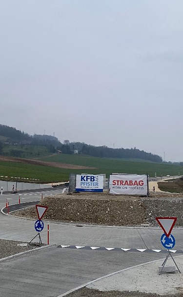Foto von gelben Bagger bei einer Baustelle von STRABAG