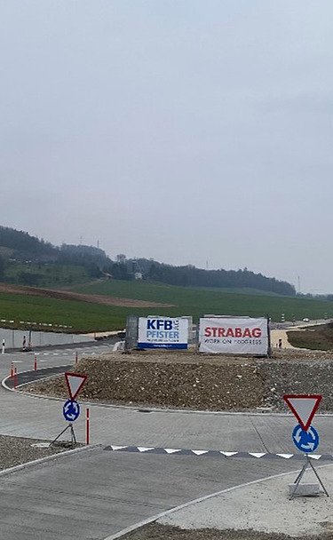 Foto von gelben Bagger bei einer Baustelle von STRABAG