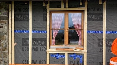 Frontales Bild auf die neue Fassade und die neuen Fensterbänke, beides aus Holz, hergestellt von den Lernenden an der Kehlmaschine