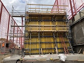 Foto von Arbeiten an einer gelben Holzschalung für Betonwände