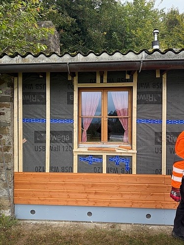 Frontales Bild auf die neue Fassade und die neuen Fensterbänke, beides aus Holz, hergestellt von den Lernenden an der Kehlmaschine