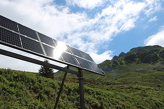 Solarpanel in den Bergen bei dem das Sonnenlicht reflektiert