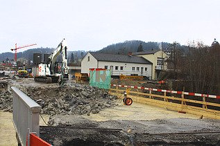 Weisser Bagger mit STRABAG Logo beim Abbruch der Wila Brücke