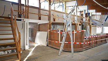 Innenausbau des Gmeindezentrumes. Viel helles Holz und rot weisse Absperrbänder.