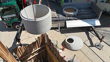Der Bohrer schüttelt Aushubmaterial ab, mit Bagger wird das Material sofort abtransportiert.