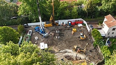 Luftaufnahme der Baustelle mit verschiedenen Bausmaschinen, die Prüfvorrichtung in der Mitte