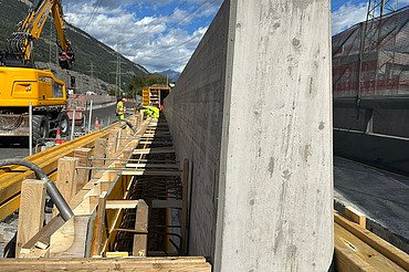 Nachaufnahme auf der Baustelle mit fertiger Mauer und Schalungselementen