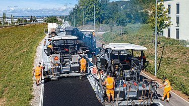 Zwei parallel laufende Fertiger beim Asphalteinbau