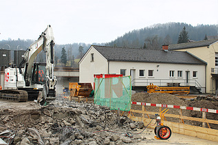 Weisser Bagger mit STRABAG Logo beim Abbruch der Wila Brücke