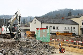 Weisser Bagger mit STRABAG Logo beim Abbruch der Wila Brücke