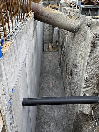 Nahaufnahme einer bereits fertig gegossenen Beton-Wand innerhalb der Baugrube